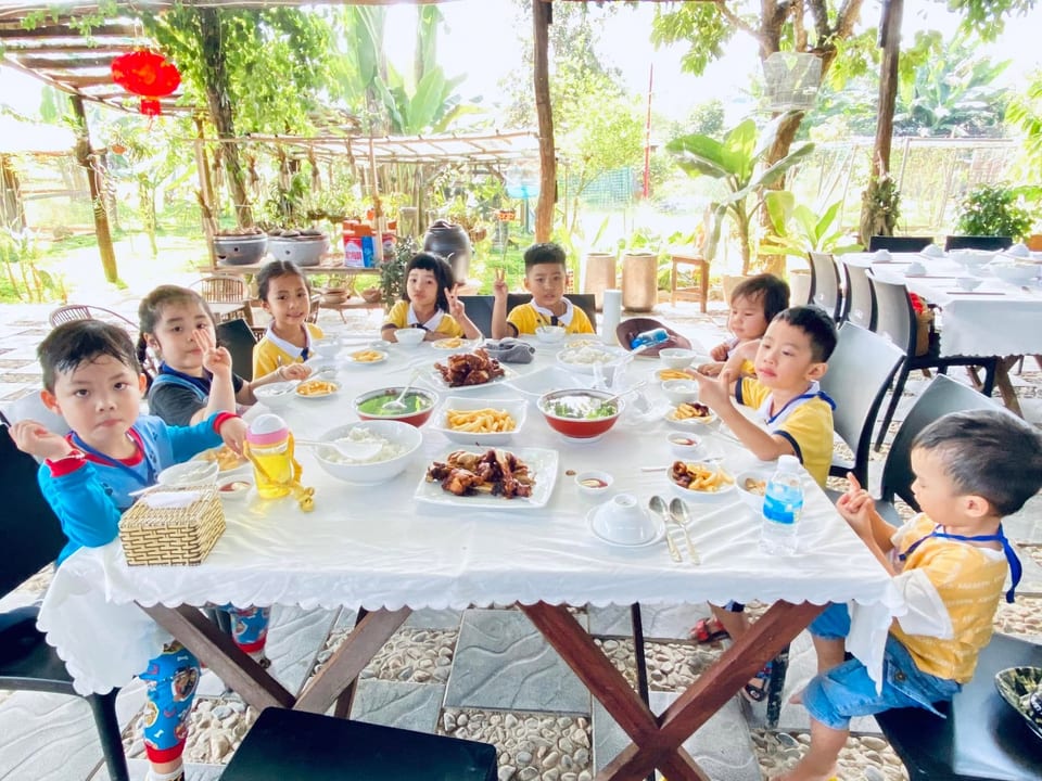 Các bé ngồi quây quần bên bàn ăn cùng nhau